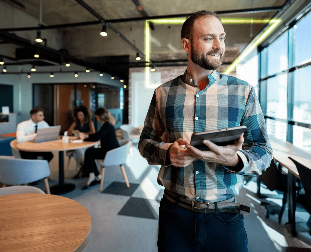 IT-Leiter mit Tablet und zufriedenem Blick dank SAP Concur