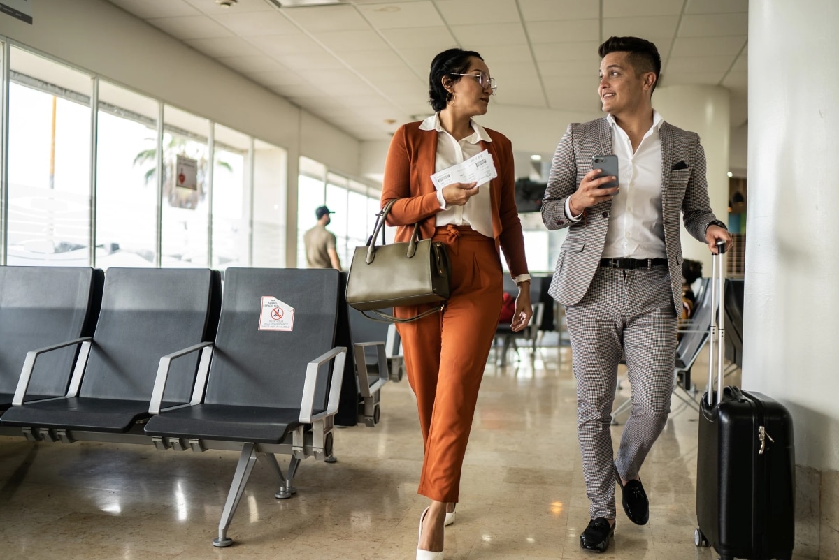 Ein Mann und eine Frau auf Geschäftsreise im Terminal eines Flughafens.