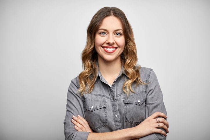 Eine junge Geschäftsreisende freut sich über den Überblick und ROI von Concur Travel & Expense.