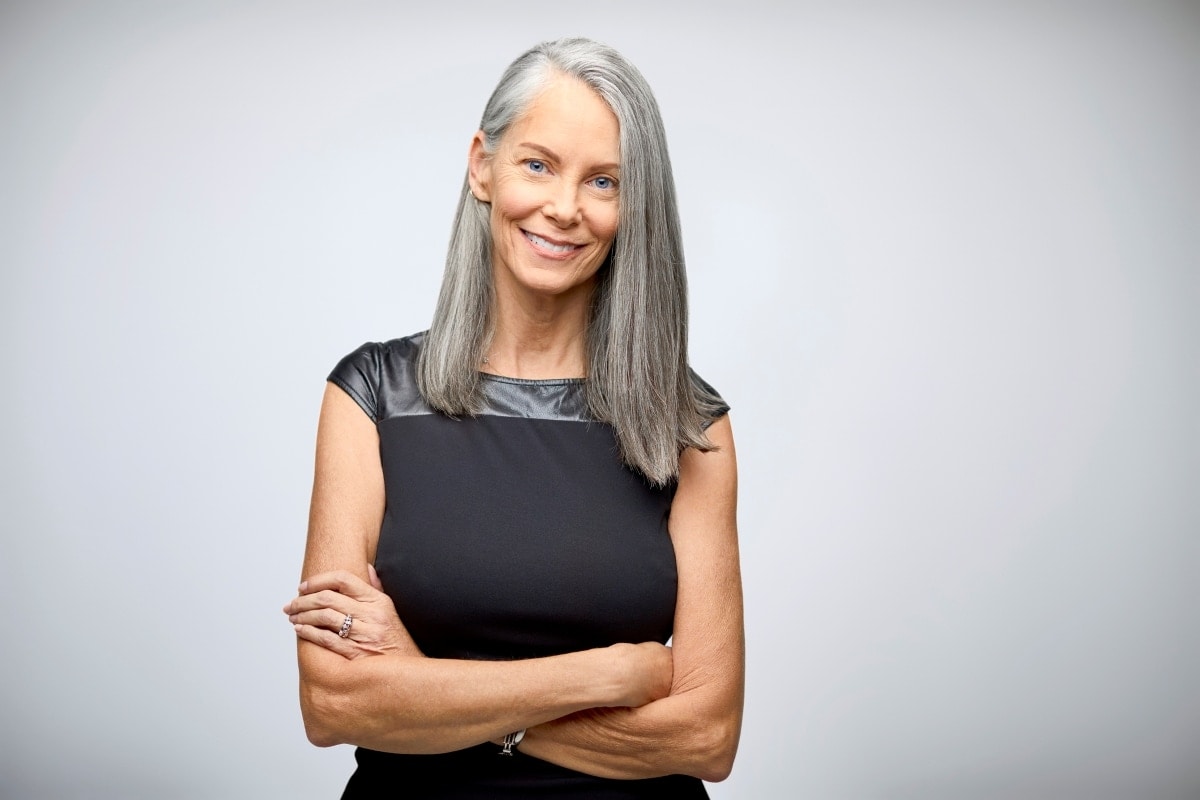 Geschäftsfrau freut sich darüber, dass sie die Compliance im Griff hat – auch wenn Chaos herrscht.