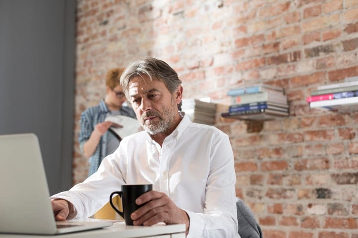 Mann informiert sich mit SAP Concur über die versteckten Kosten der Nutzung getrennter Finanzsysteme.