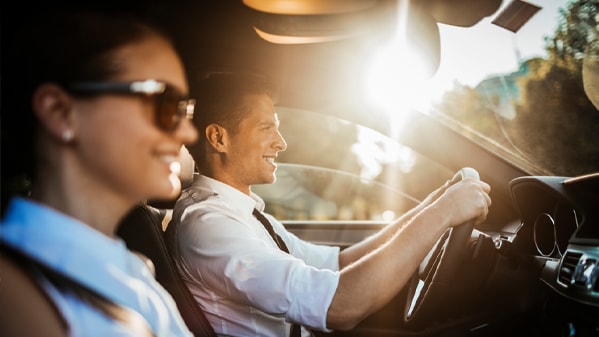 Ein Mitarbeiter am Steuer eines Fahrzeugs während einer geschäftlichen Dienstfahrt.