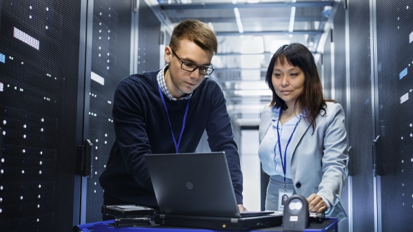 Zwei IT-Experten analysieren Daten für die digitale Finanztransformation am Computer.