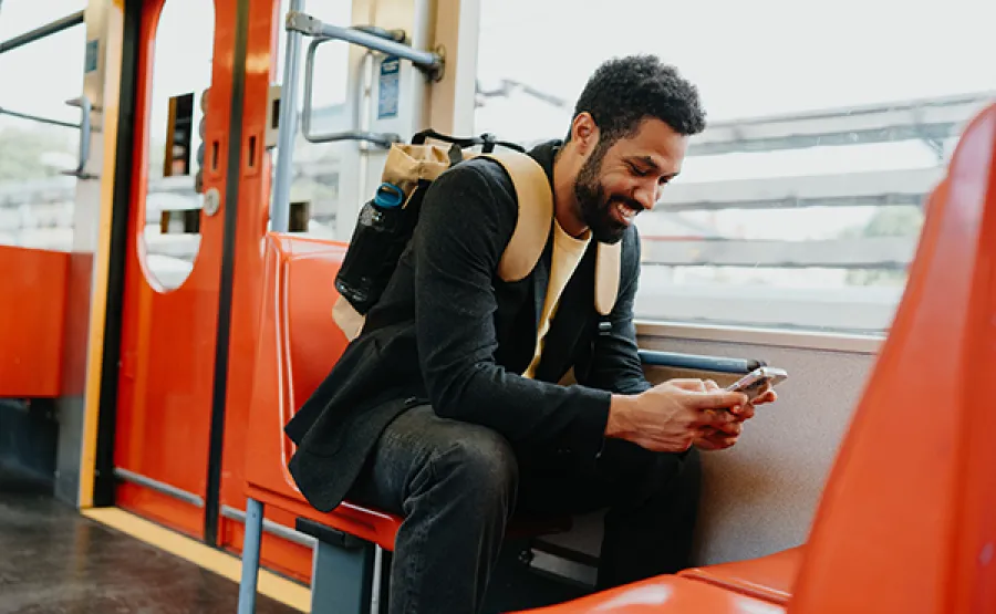Nachhaltiges Reisen: Geschäftsreisende Person nutzt das Smartphone im Zug.