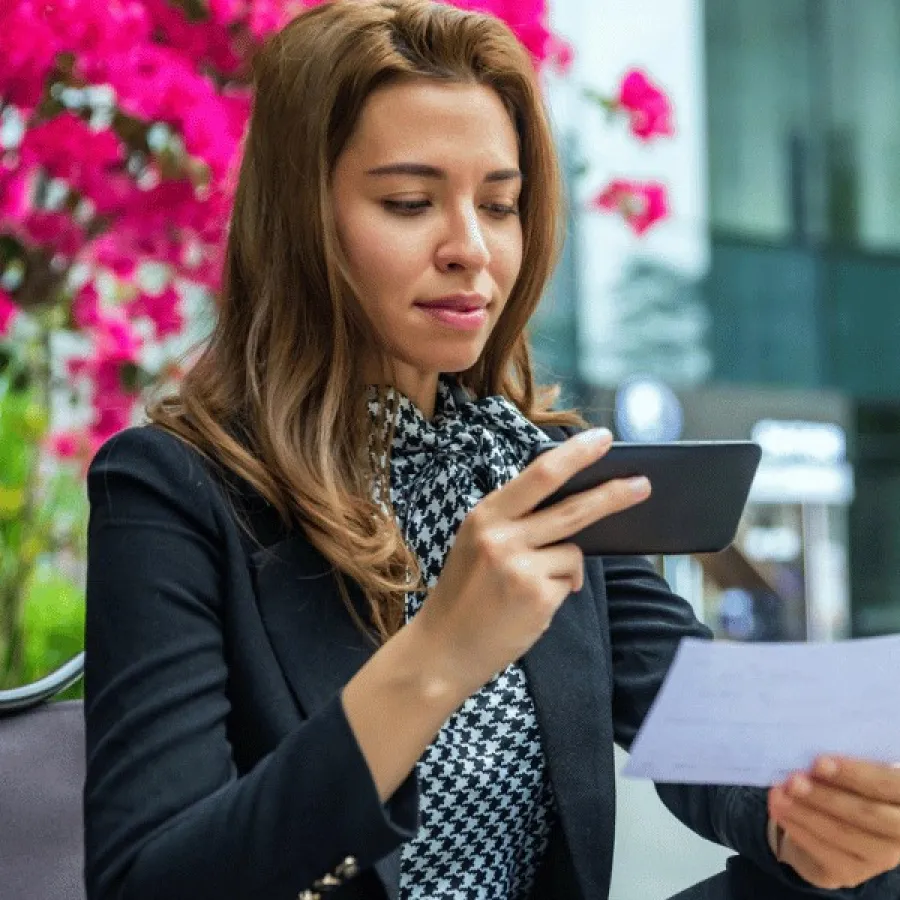 Eine Person fotografiert einen Spesenbeleg mit dem Smartphone zur KI-gestützten Prüfung.