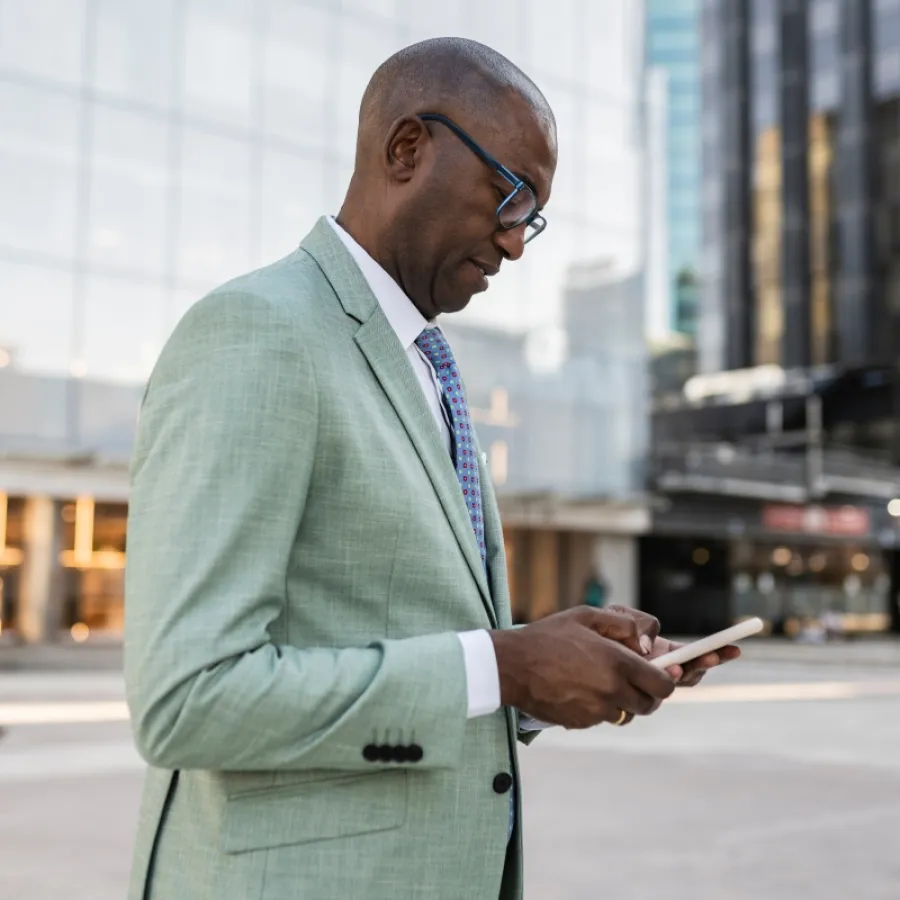 Geschäftsreisender nutzt eine Reisekostenabrechnung App auf dem Smartphone im Finanzviertel.