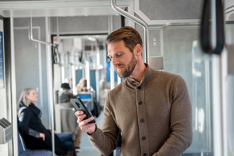 man in train with mobile phone