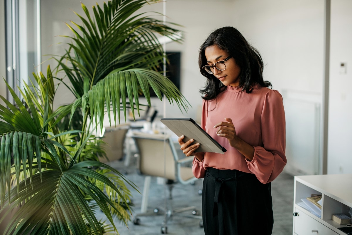 Finanzfrau liest Insights zur Rolle des CFO im Talent Management am Tablet.